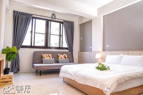 a bedroom with a large bed and a couch at Alley-巷弄75包棟民宿 in Yilan City