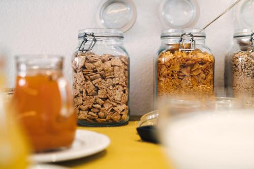 a table with four jars of different types of granola at Hotel Regina in Serfaus