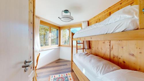 een slaapkamer met 2 stapelbedden in een tiny house bij Truoch in Samedan