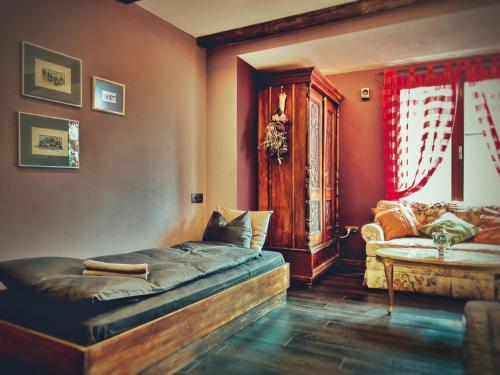 sypialnia z łóżkiem i kanapą w pokoju w obiekcie Тhe Bohemian Lodge-entire house with sauna w mieście Wielkie Tyrnowo