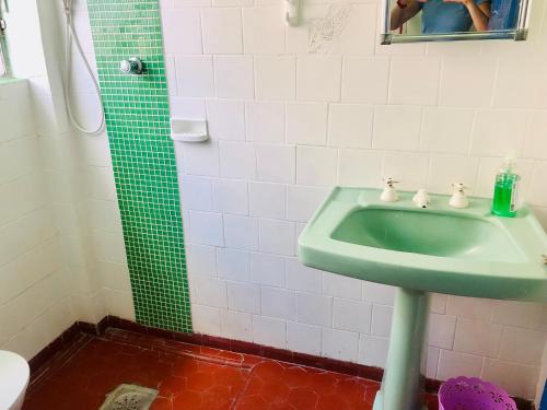 a bathroom with a green sink and a shower at Casa Gris in Praia Grande