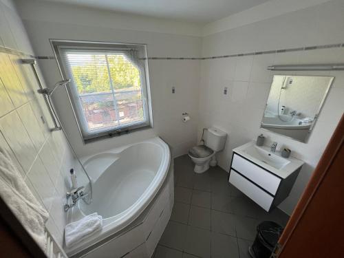 a bathroom with a tub and a toilet and a sink at Restaurace Pyramida in Karlovy Vary