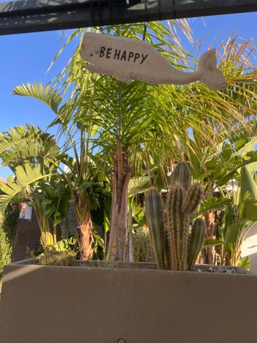 Un signe qui dit être heureux devant les plantes dans l'établissement Florí, à Reitani