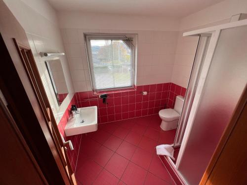 a red bathroom with a sink and a toilet at Restaurace Pyramida in Karlovy Vary