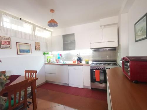 a kitchen with white cabinets and a stove top oven at La Casa di Mosè in Vigna di Valle