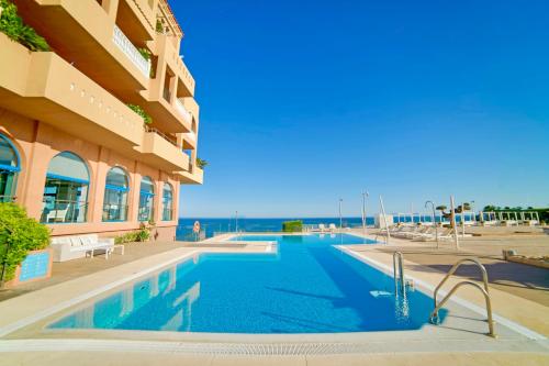 a swimming pool in front of a building at Casamaïa Apartments in Benalmádena