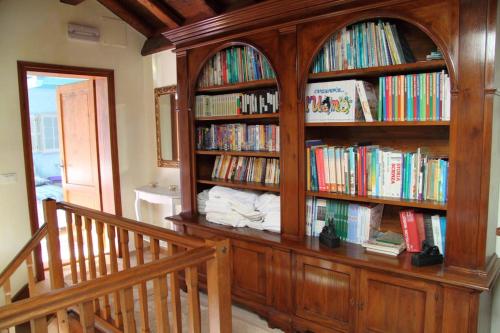 a large wooden book shelf filled with books at The Duck's Cottage in Feltre
