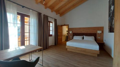 1 dormitorio con 1 cama y un banco en una habitación en Corte Varola B&B Zia Marisa, en Belluno