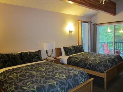 a hotel room with two beds and a window at The Lodge At Skeena Landing in Terrace