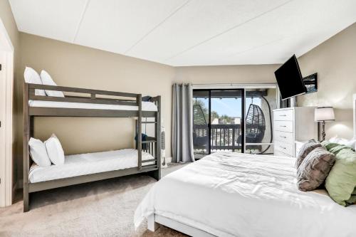 a bedroom with two bunk beds and a balcony at Sunrise Escape in Saint Augustine