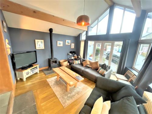 a living room with a couch and a tv at Inglefall & Jasmine Cottages in Ingleton 