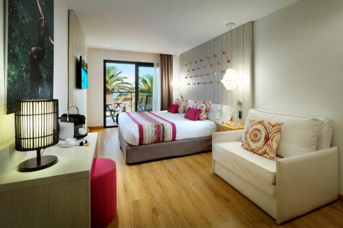 プラヤ・デン・ボッサにあるGrand Palladium White Island Resort & Spa - All Inclusiveのベッドとソファ付きのホテルルーム