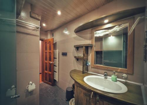 La salle de bains est pourvue d'un lavabo et d'un miroir. dans l'établissement Тhe Bohemian Lodge-entire house with sauna, à Veliko Tarnovo