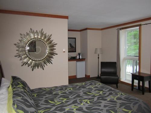 a bedroom with a bed and a mirror on the wall at The Lodge At Skeena Landing in Terrace