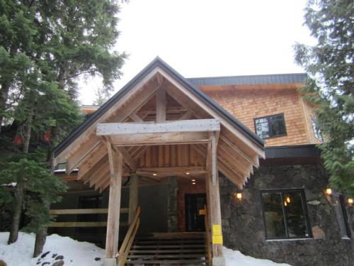 a house with a gambrel roof with snow on the ground at The Lodge At Skeena Landing in Terrace