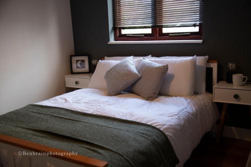 een slaapkamer met een bed met witte lakens en kussens bij No31 Apartment Cardiff in Cardiff