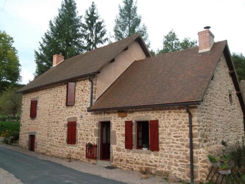 a small stone building with red shutters on it at Gîte Familial avec Cascade, Pêche, Activités et Proximité de Vichy - FR-1-489-21 in Barrais-Bussolles
