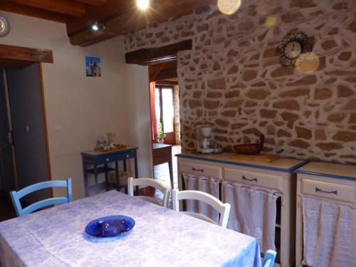een keuken met een tafel en een stenen muur bij Gîte Barrais-Bussolles, 5 pièces, 8 personnes - FR-1-489-21 in Barrais-Bussolles
