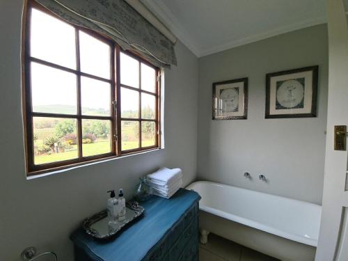 a bathroom with a bath tub and a window at The Falls Cottages in Balgowan