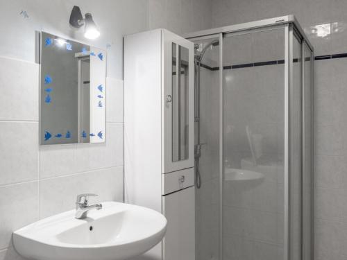 a white bathroom with a sink and a shower at Gîte Cressanges, 3 pièces, 4 personnes - FR-1-489-57 in Cressanges