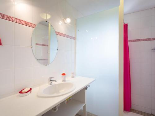 une salle de bain blanche avec un lavabo et un miroir dans l'établissement Gîte Familial et Confortable avec Jardin, Cheminée et Proximité Nature - Animaux Acceptés - FR-1-489-41, à Ferrières-sur-Sichon