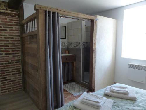 ein Bad mit Dusche und ein Bett mit Handtüchern in der Unterkunft Gîte Vaumas, 5 pièces, 8 personnes - FR-1-489-99 in Vaumas