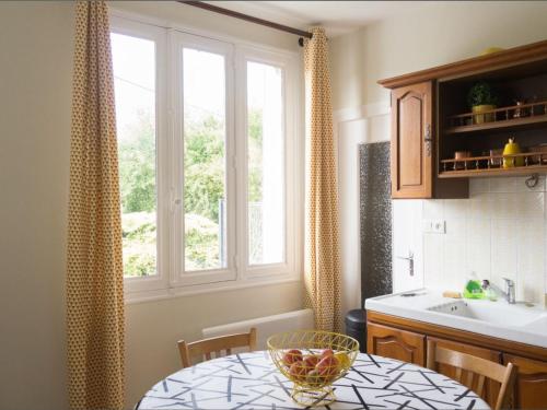 une cuisine avec une table, un évier et une fenêtre dans l'établissement Gîte familial en Auvergne avec jardin, ping-pong, proche stations thermales, animaux acceptés - FR-1-489-127, à Mazirat