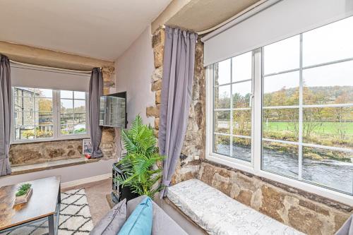 a living room with large windows and a couch at Bridge End Mill by Guestz in Settle
