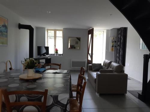un salon avec une table et un canapé dans l'établissement Charmante Fermette avec Jardin, Proche Randonnées et Ski, à Lavoine - FR-1-489-136, à Lavoine