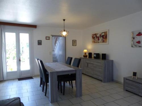 une salle à manger avec une table et des chaises dans l'établissement Maison cosy à Moulins : proche centre, cour fleurie, vélos, WiFi et draps fournis - FR-1-489-162, à Moulins