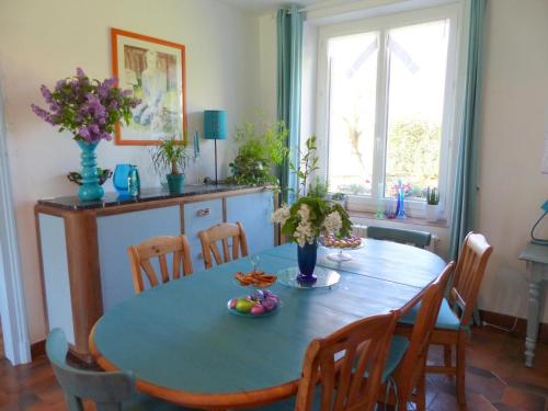 a dining room with a blue table and chairs at Maison de campagne idéale pour familles, cavaliers, animaux acceptés, avec jardin clos et tout équipé. - FR-1-489-172 in Barrais-Bussolles