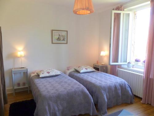 a bedroom with two beds and a window at Maison de campagne idéale pour familles, cavaliers, animaux acceptés, avec jardin clos et tout équipé. - FR-1-489-172 in Barrais-Bussolles