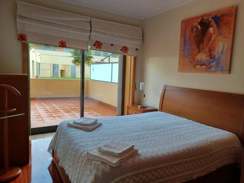 - une chambre avec un lit et une grande fenêtre dans l'établissement Alojamento Varandas do Parque com INTERNET, à Póvoa de Varzim