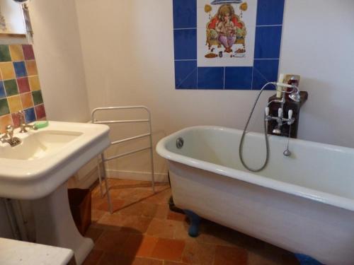 La salle de bains est pourvue d'une baignoire blanche et d'un lavabo. dans l'établissement Gîte Beaune-d'Allier, 5 pièces, 8 personnes - FR-1-489-228, à Beaune dʼAllier