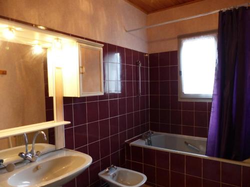 ein Badezimmer mit einem Waschbecken, einer Badewanne und einem Spiegel in der Unterkunft Gîte Saint-Germain-des-Fossés, 5 pièces, 8 personnes - FR-1-489-248 in Saint-Germain-des-Fossés
