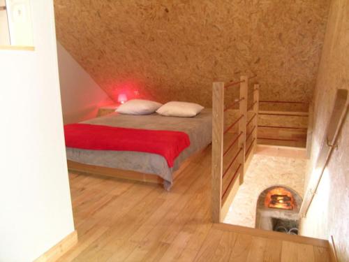 um quarto com uma cama com um cobertor vermelho em Gîte Vernusse, 2 pièces, 2 personnes - FR-1-489-208 em Vernusse