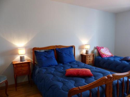 ein Schlafzimmer mit einem Bett mit blauer Bettwäsche und zwei Lampen in der Unterkunft Gîte Arfeuilles, 5 pièces, 11 personnes - FR-1-489-280 in Arfeuilles