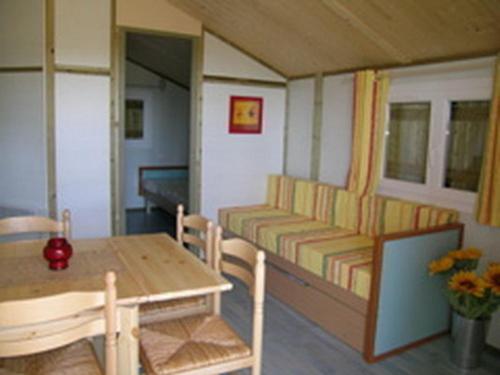 a room with a table and a couch and a table and chairs at Gîte Échassières, 3 pièces, 5 personnes - FR-1-489-288 in Échassières