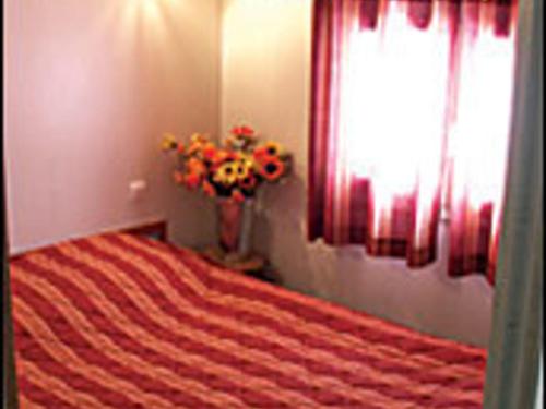 una camera da letto con un letto e un vaso di fiori di Chalet familial avec piscine, animaux acceptés, draps inclus, proche de Montluçon et Gannat - FR-1-489-323 a Échassières