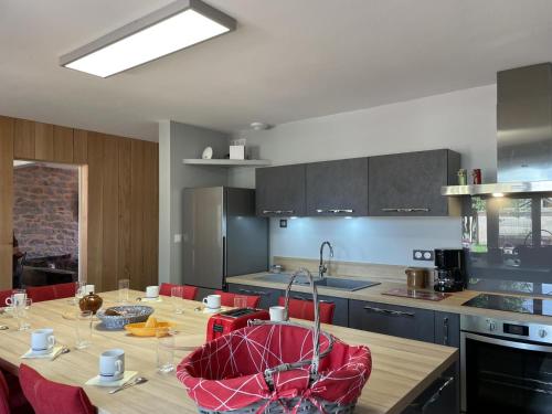 une cuisine avec une table en bois et des chaises rouges dans l'établissement Gîte champêtre rénové avec jardin et équipements modernes à Pierrefitte-sur-Loire - FR-1-489-334, à Pierrefitte-sur-Loire