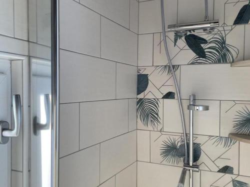 uma casa de banho com um chuveiro com azulejos brancos em Gîte Pierrefitte-sur-Loire, 5 pièces, 9 personnes - FR-1-489-334 em Pierrefitte-sur-Loire