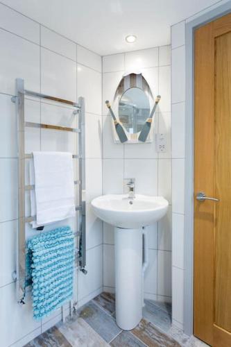 a white bathroom with a sink and a mirror at Pickwick's Place in Broadstairs - Exclusive unmissable deals! Book now before it's too late! in Broadstairs