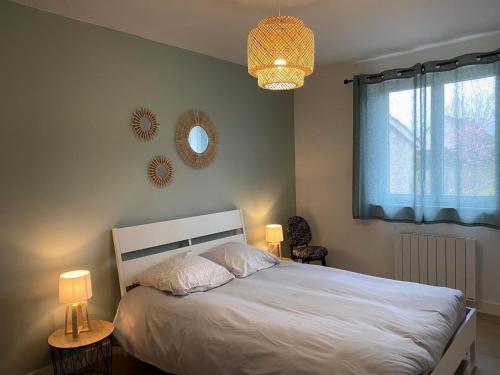 una camera da letto con un letto con due lampade e una finestra di Gîte Villeneuve-sur-Allier, 3 pièces, 4 personnes - FR-1-489-372 a Villeneuve-sur-Allier