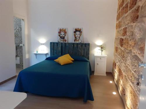 - une chambre dotée d'un lit bleu avec deux masques sur le mur dans l'établissement Camere Stella del Sud Makari, à Macari