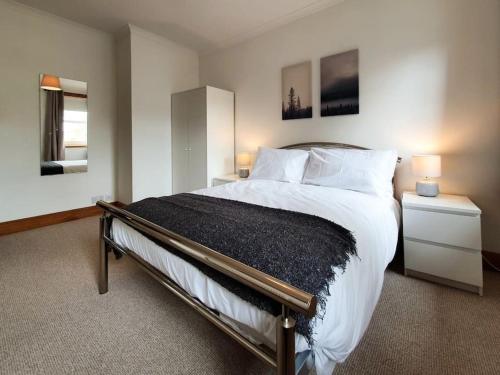 um quarto com uma cama grande com lençóis brancos e almofadas em Parkgate Apartment - Near M90, Amazon, Edinburgh em Rosyth