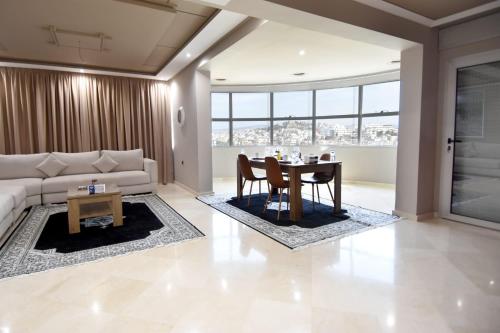 ein Wohnzimmer mit einem Sofa und einem Tisch in der Unterkunft Hotel Appartement Tanger in Tangier