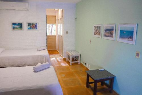 a room with two beds and a table in it at Qavi - Villa Jacumã #Luxo in Jacumã