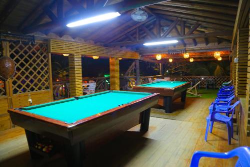two ping pong tables in a bar with blue chairs at Hotel Camino Verde in Tolú