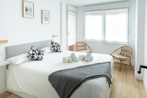 a bedroom with a large white bed with two towels on it at Mundaka Centre by Urdaibai Rentals in Mundaka
