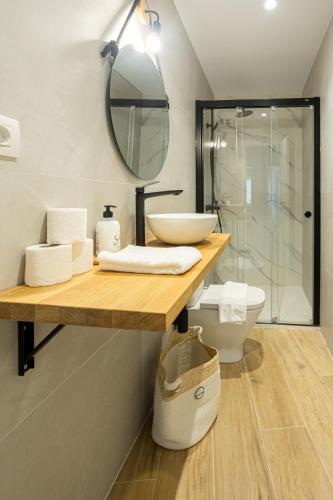a bathroom with a sink and a toilet and a mirror at MUNDAKA Centre 1 in Mundaka
